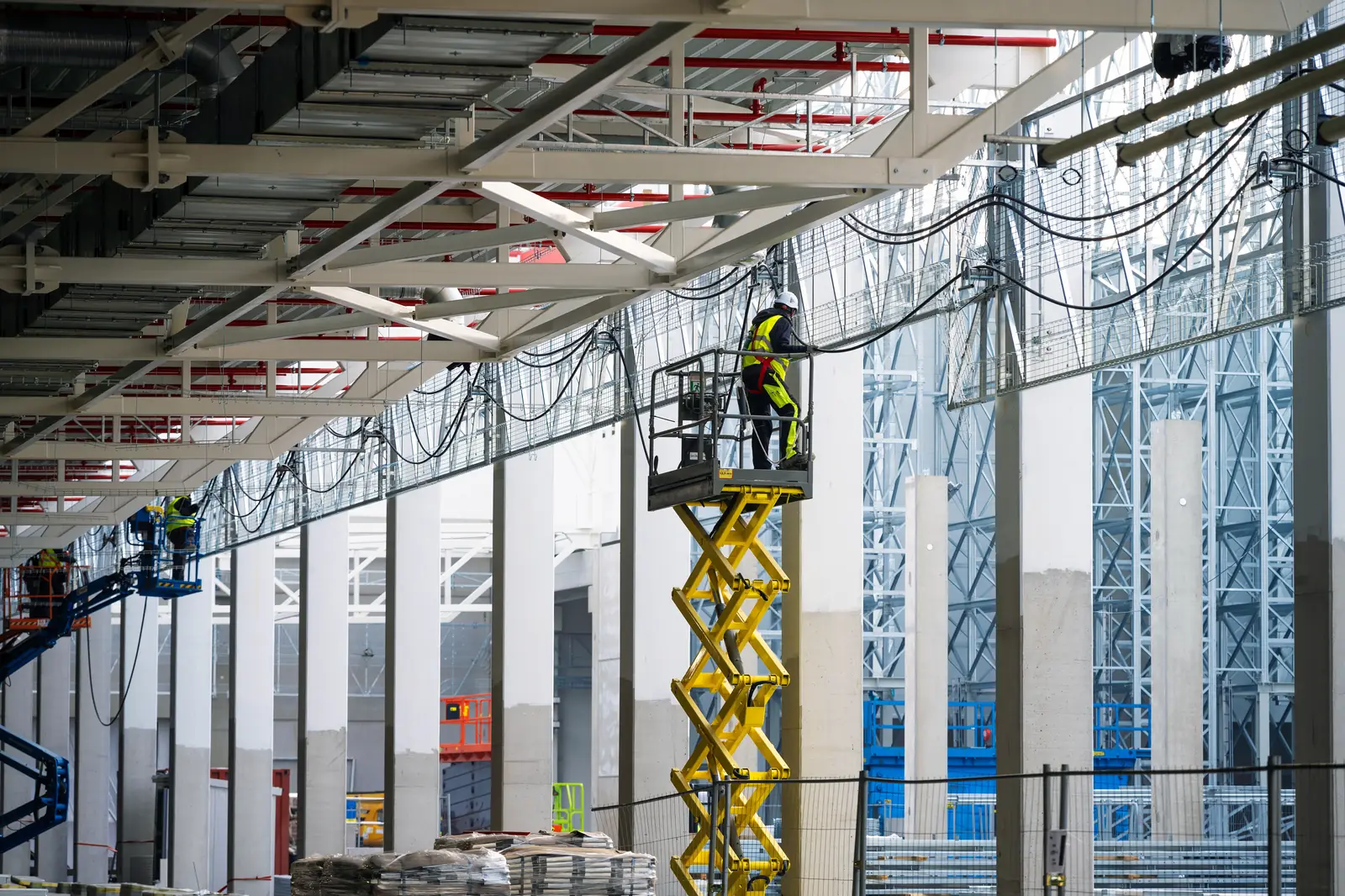 Technicians installing cabling pathways in a data hall.