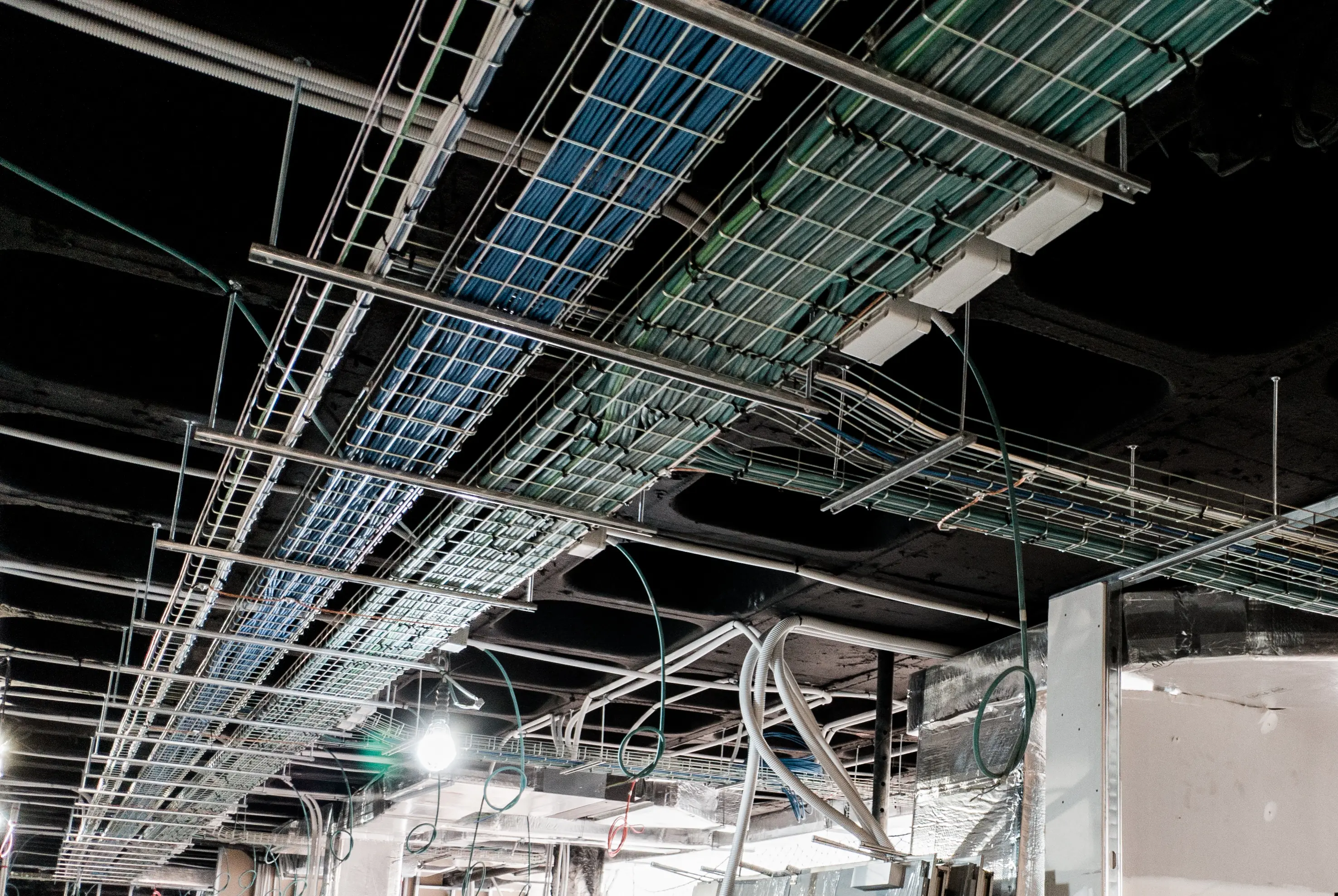Infrastructure work taking place above a finished interior ceiling.